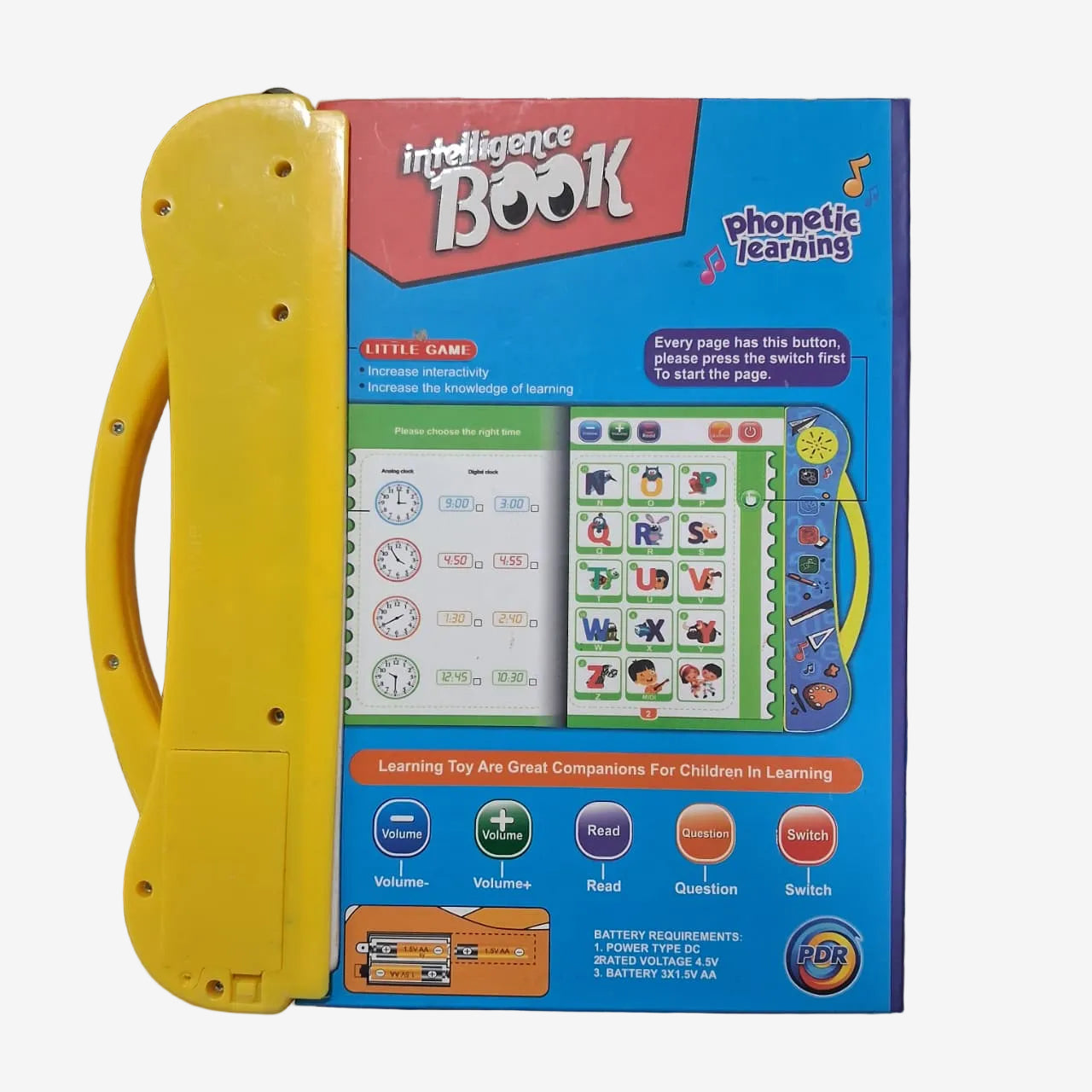 A children's toy learning book with a bright yellow handle and a blue front cover, photographed on a cluttered desk with school supplies visible around it.