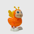 A colorful plastic toy bee with yellow wings and antennae, blue eyes, and white feet, displayed on a glass table inside a toy store.