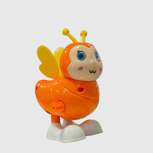 A colorful plastic toy bee with yellow wings and antennae, blue eyes, and white feet, displayed on a glass table inside a toy store.